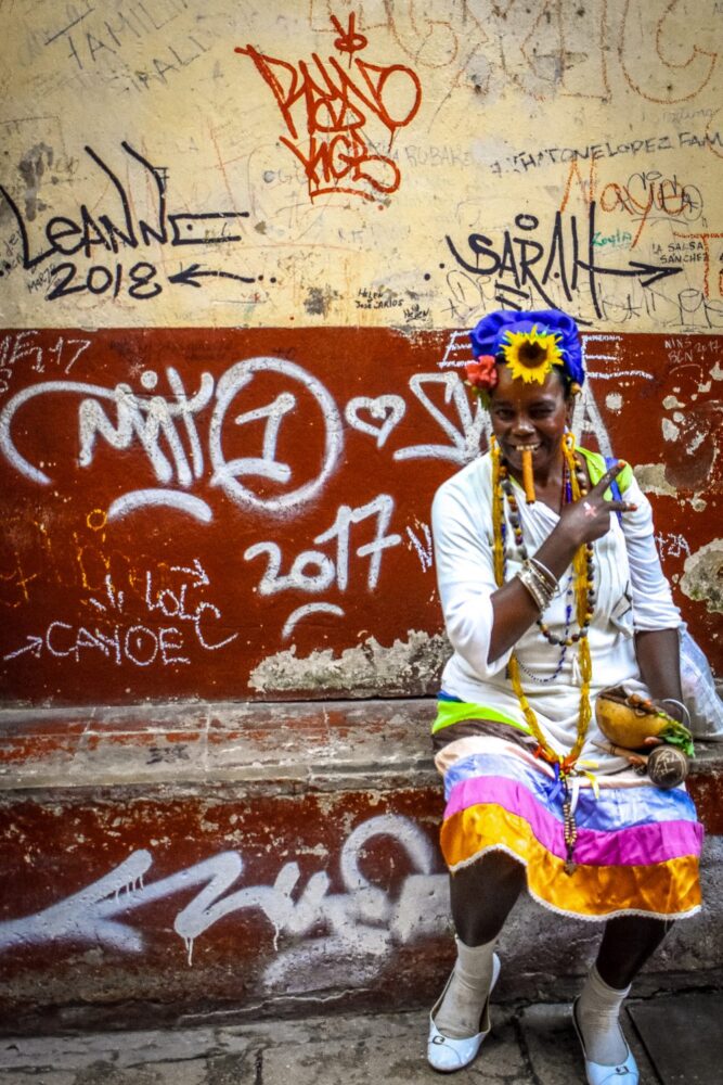 woman posing with a cigar and flowers in cuba 