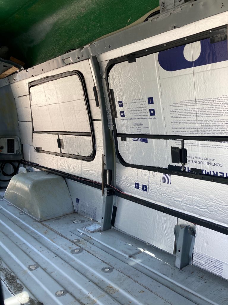 Polyiso board insulation covering several windows and the interior of the van. Things we love about our campervan