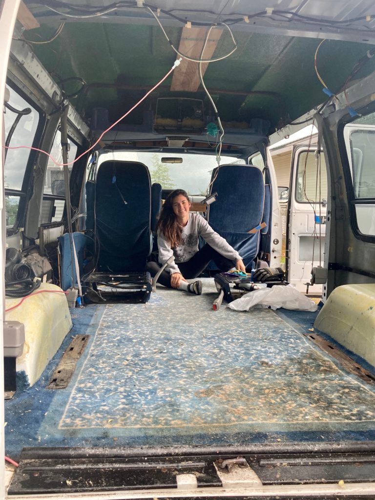 gutting conversion van costs. Blue stained carpets and woman brown hair sitting on them. 