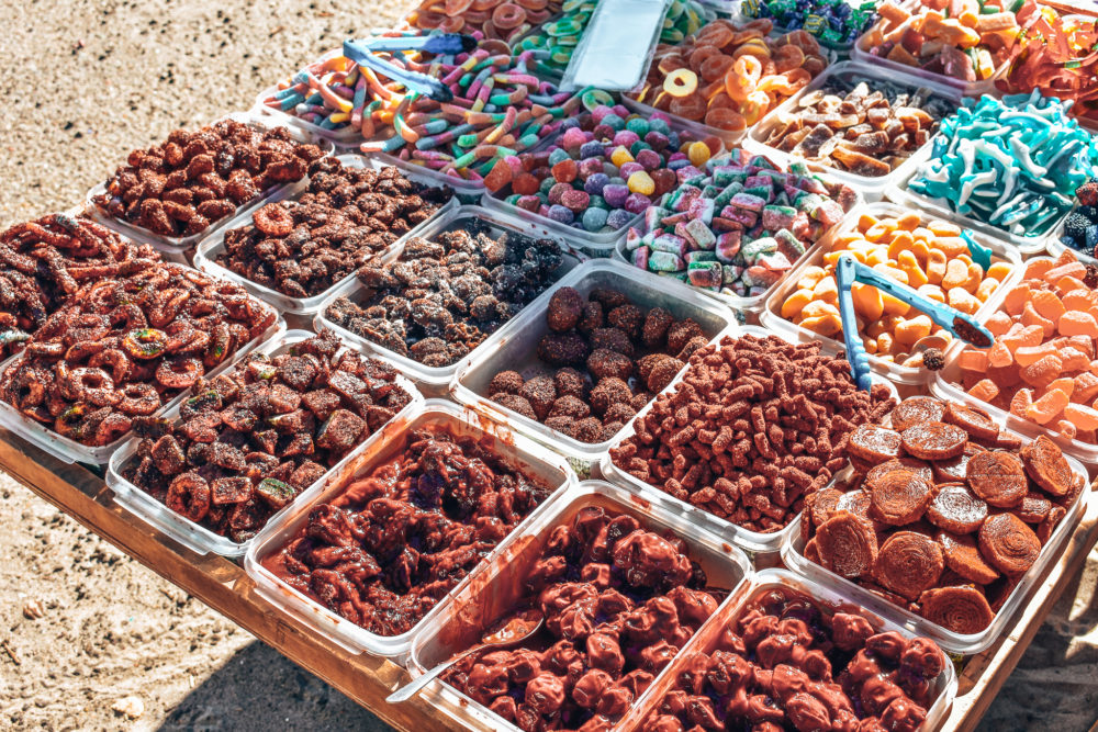 Mexican candy being sold in plastic containers outside. 
