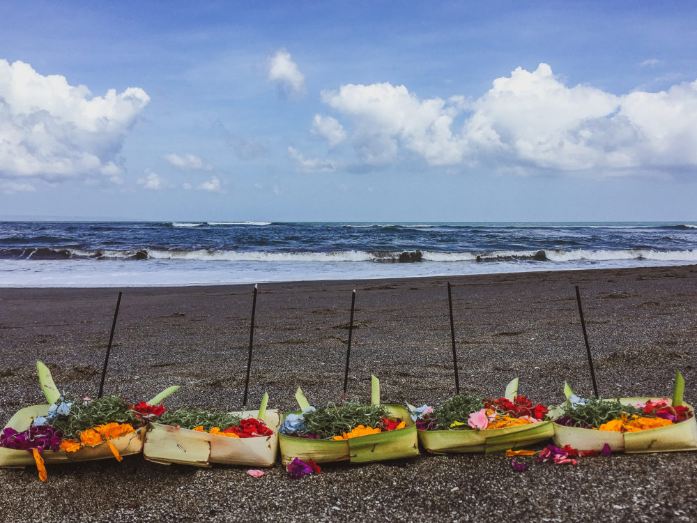 green banana leaf offerings filled with flowers on a beach. Cultural travel 