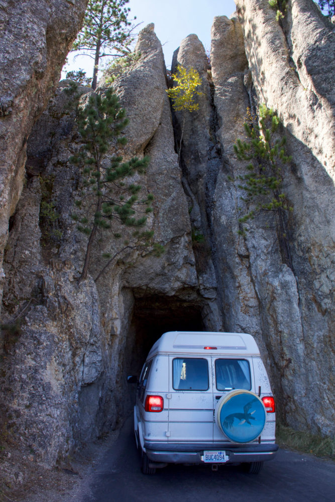 white van squeezing through small space in a rocky cliff. reasons not to buy a sprinter for van life 