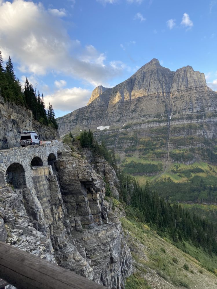 rocky hillside road with a van driving on the scenic rocky bridge. 