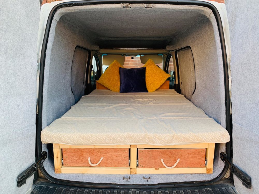 inside view of a small van with a bed built inside. 