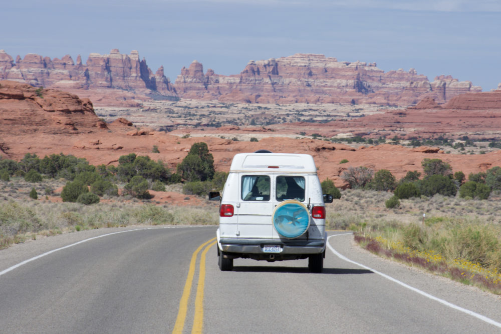 Van driving on desert roadway into the desert 