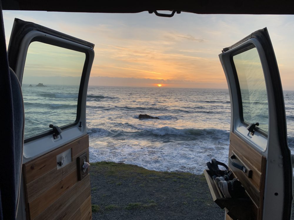 view from open van doors of the waves and ocean. 