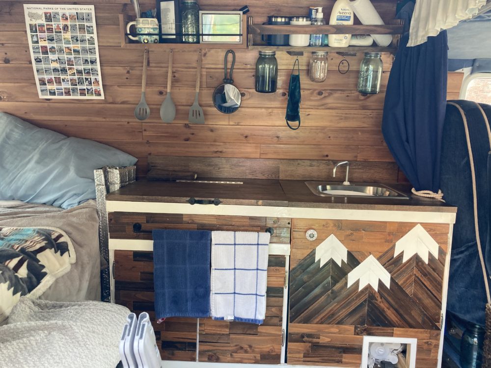 the interior of my van build. A kitchen with mountains made of wood on the drawers. 