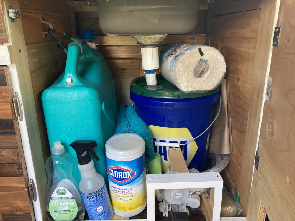 Our grey water and water tanks underneath the sink in our van. 