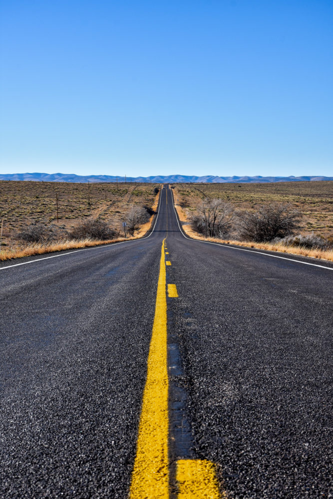 road in New Mexico with vast desert around it 