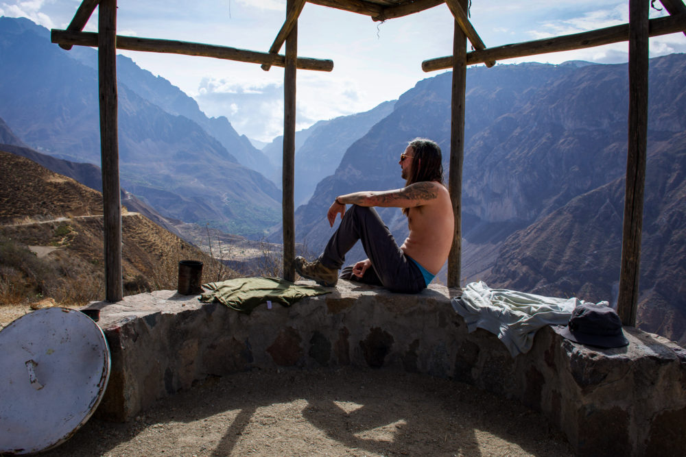 Man sitting on top of an overlook of the Colca Canyon 