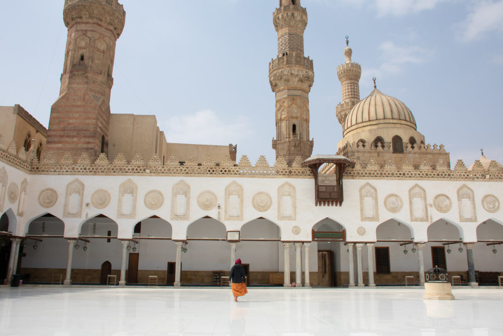 Woman walking in white mosque of Cairo. 