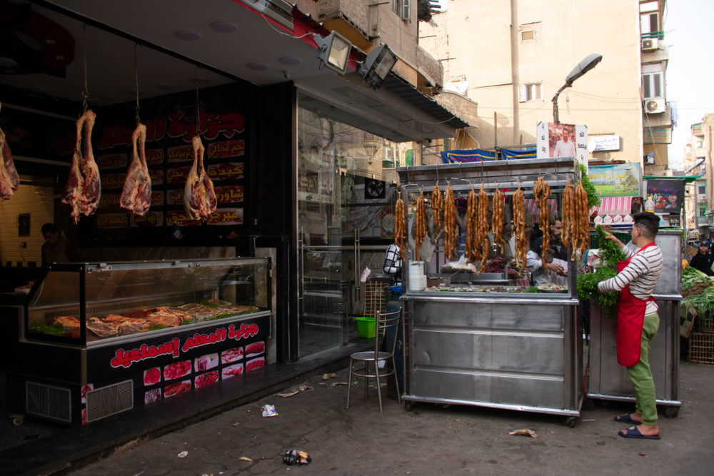 street scene of Cairo. Meat hanging in shop. 