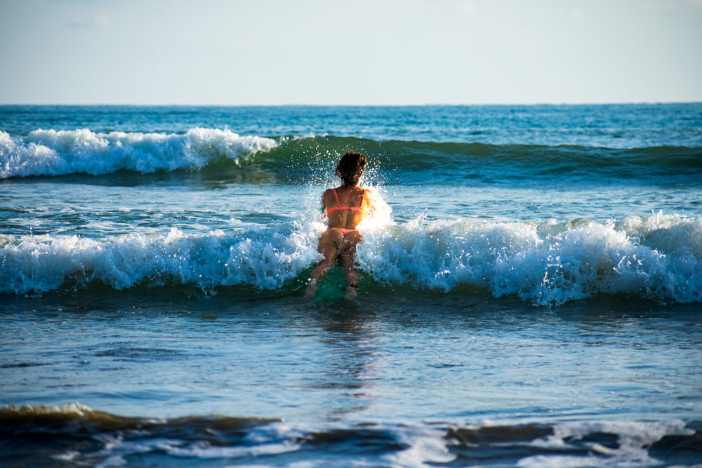 Woman surfing at Uvita beach 