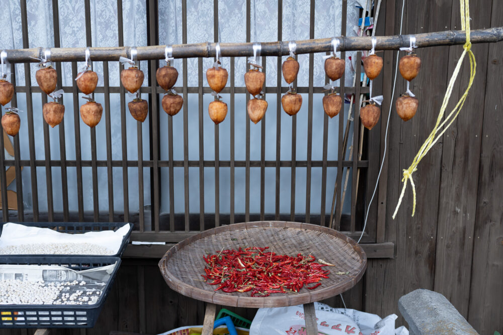 A basket of red chilli peppers near a window. 