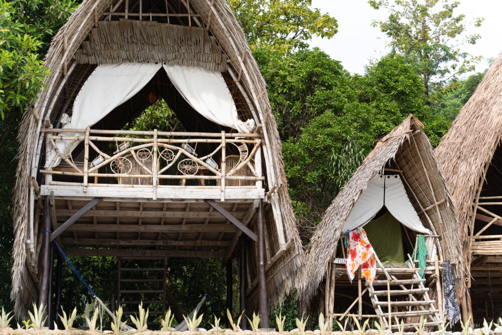 Two traditional huts on the beach at the Isla Experience