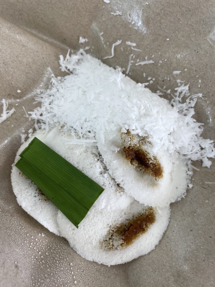 Small white desserts filled with palm sugar and coconut 