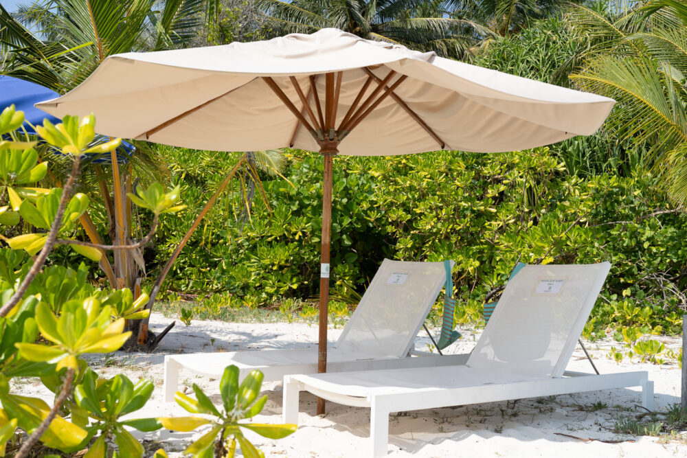 Lounge chairs on a white sand beach in Omadhoo 