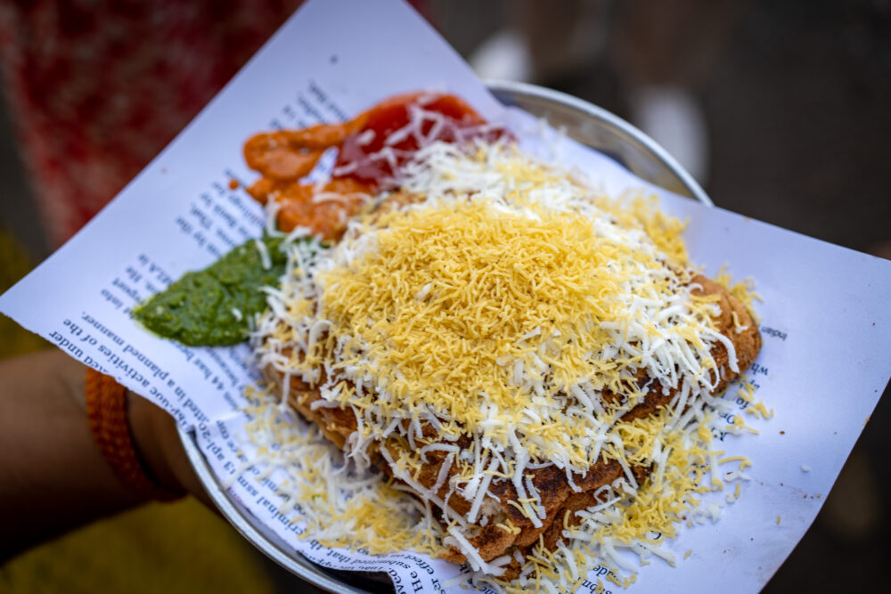 A Mumbai street food tour sandwich covered in cheese