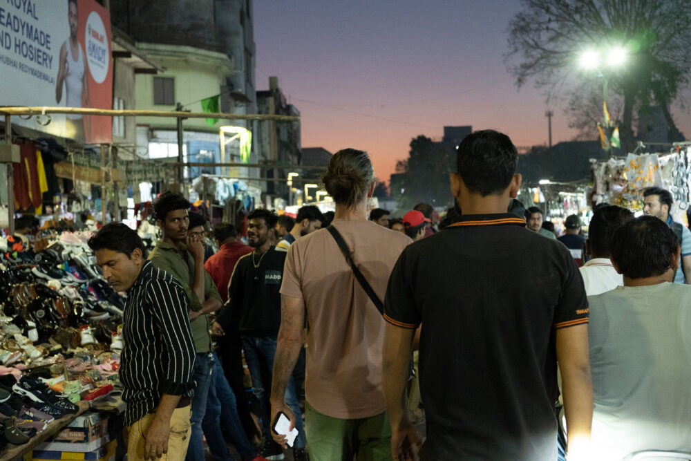 Man walking through a crowded market after dark in India 