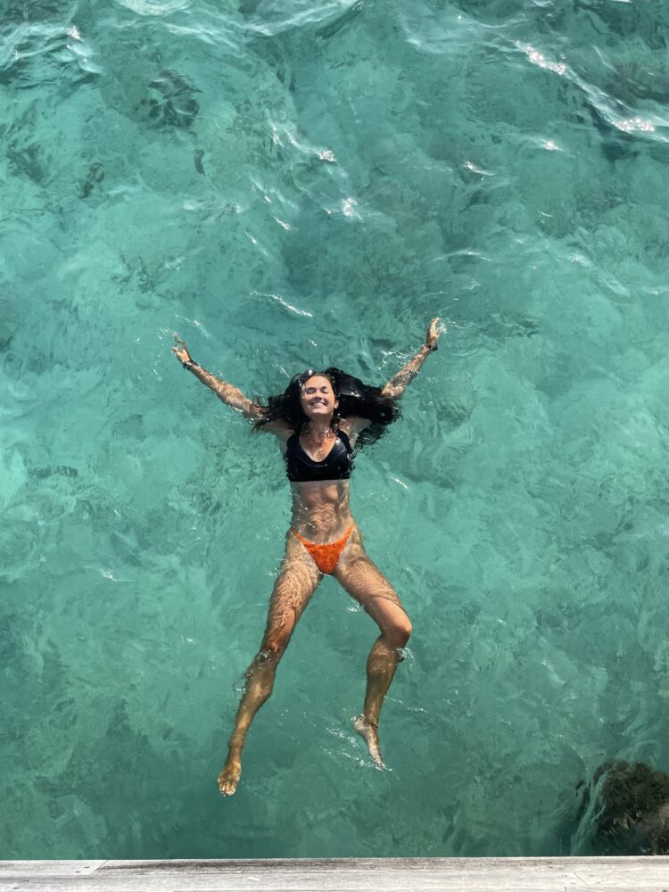 Woman swimming in the ocean in the maldives 