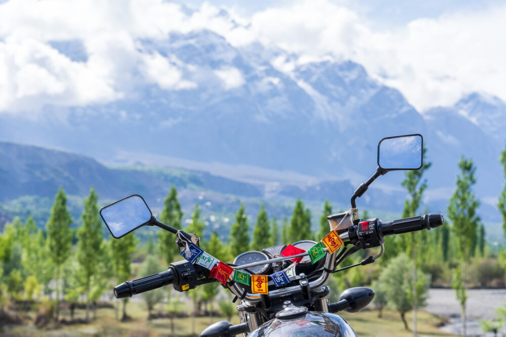 motorcycle with prayer flags on it with a mountain in the background 