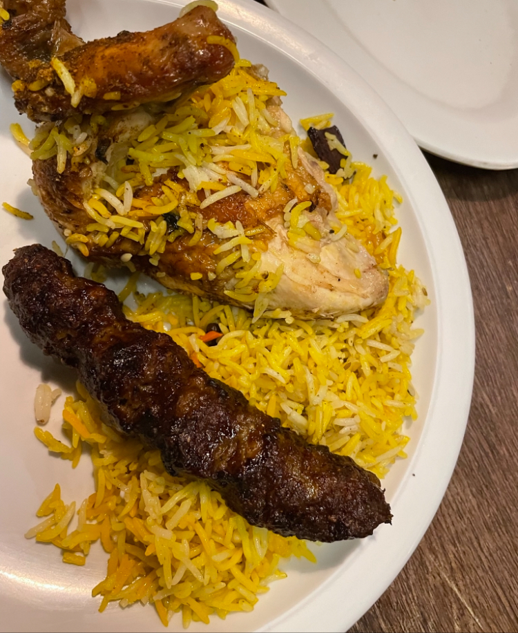 close up of yellow biryani and grilled chicken 