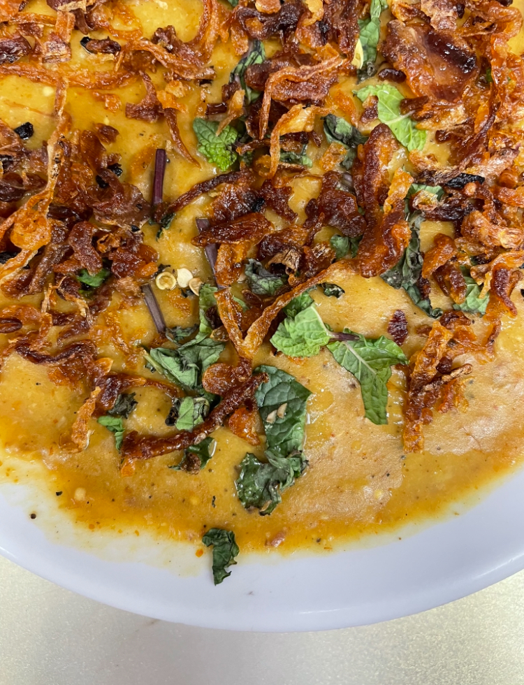 haleem with onions and cilantro on top 