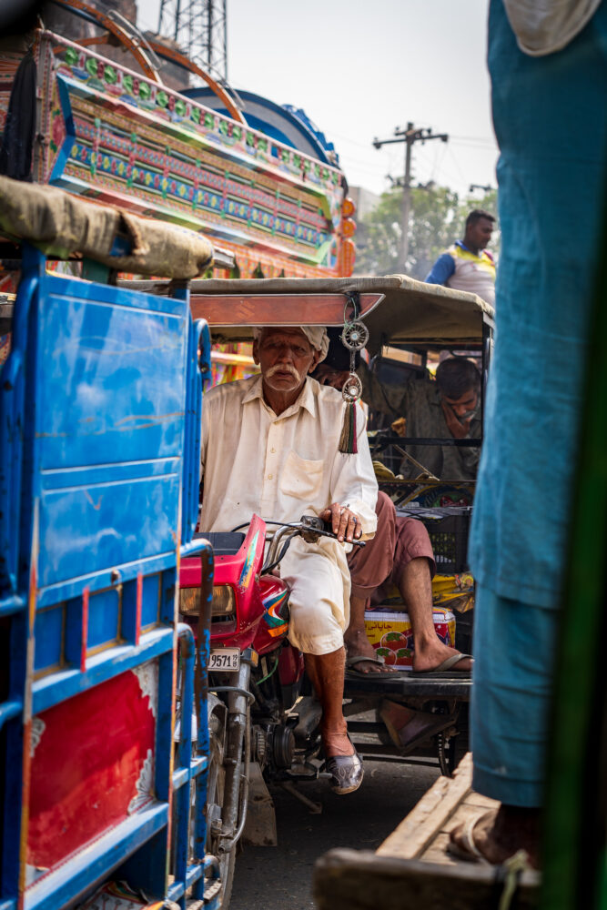a rickshaw driver in crowded traffic 