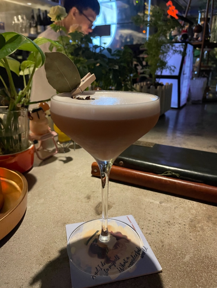 coupe glass cocktail with a leaf garnish