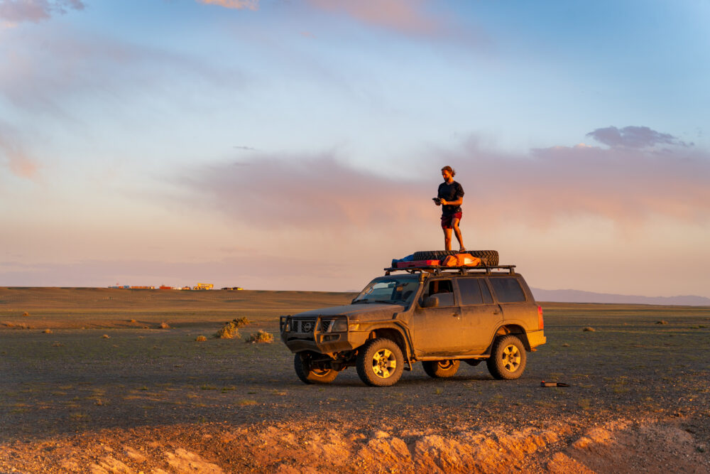 Evan standing on top of our rental car during sunset. 