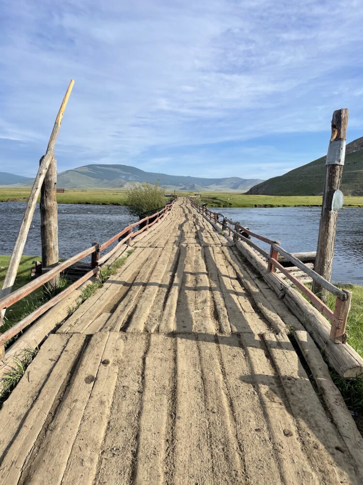 a wooden bridge going across the river 