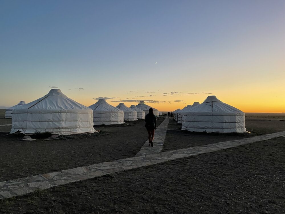 a ger camp during the orange sunset in Mongolia