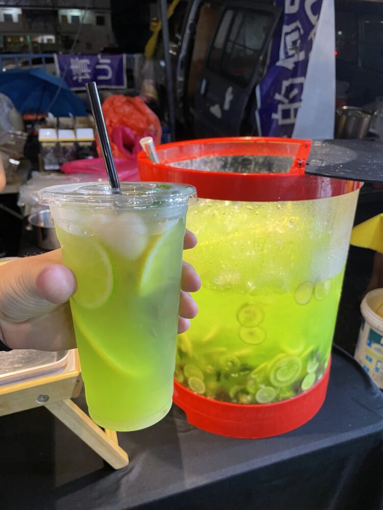 a bright green iced drink served at a market 