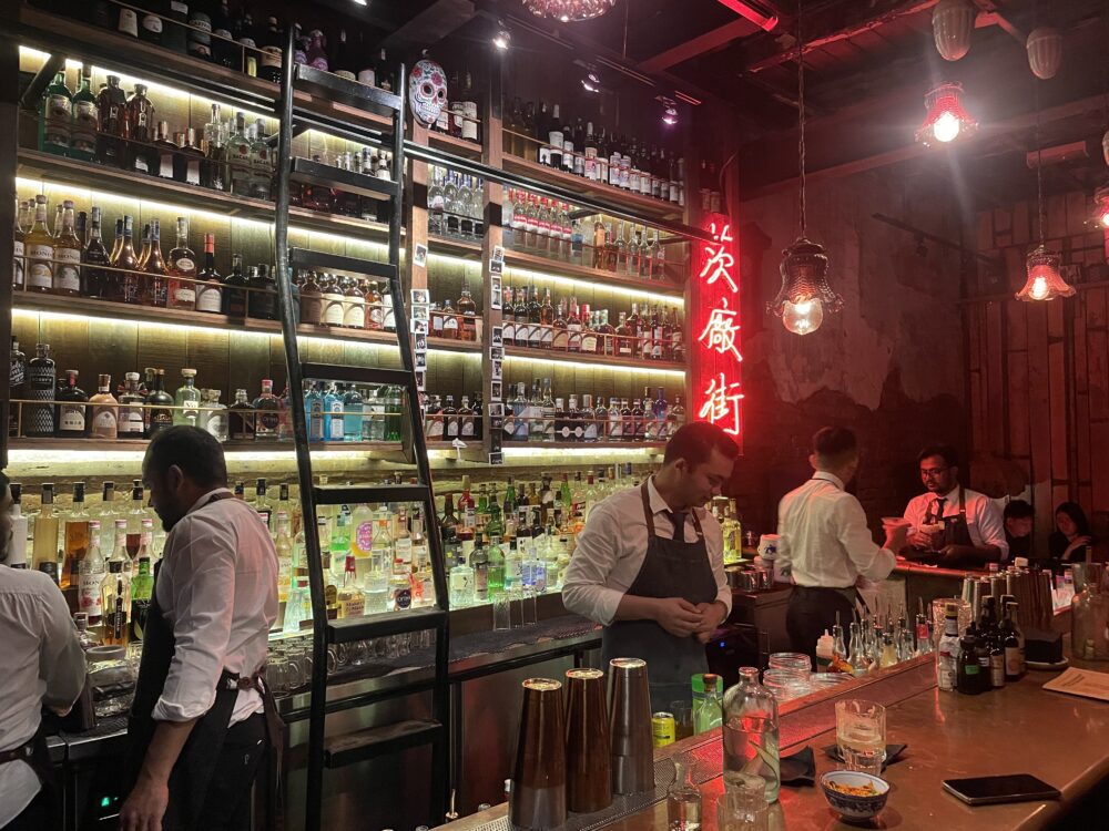 a brightly lit bar top with tons of liquor on the shelves behind it. Where to Eat in Kuala Lumpur