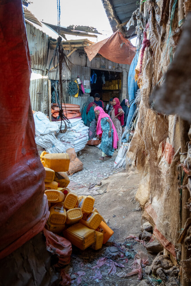 A narrow alleyway crowded with people and goods