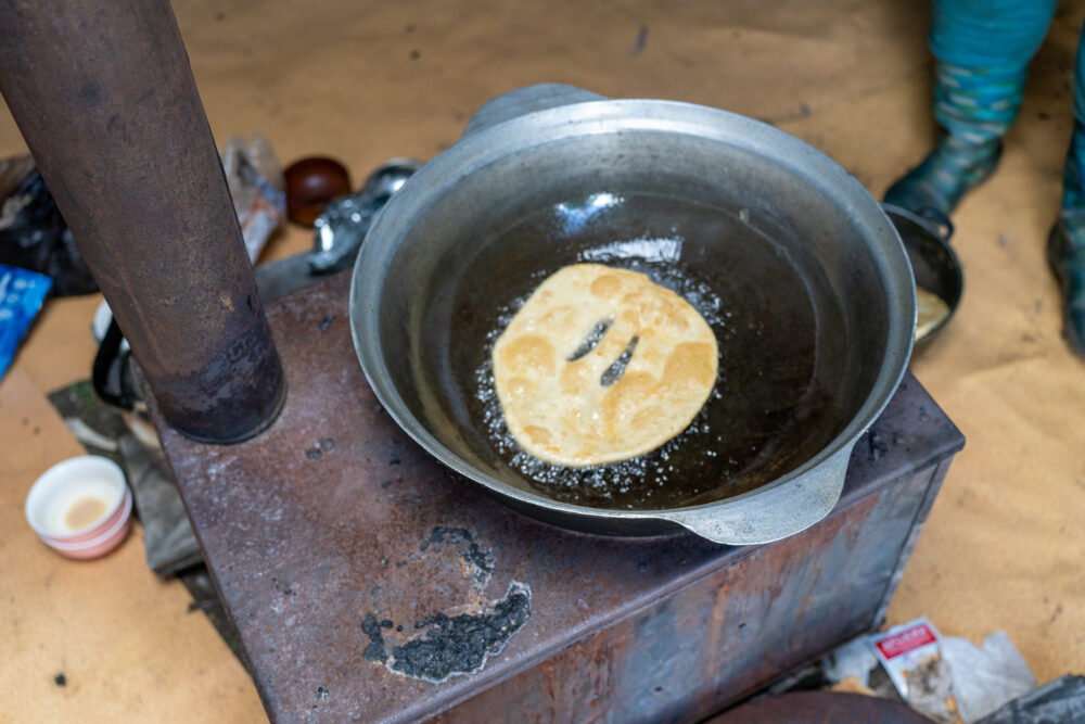 a frybread cooks on a stovetop in Mongolia