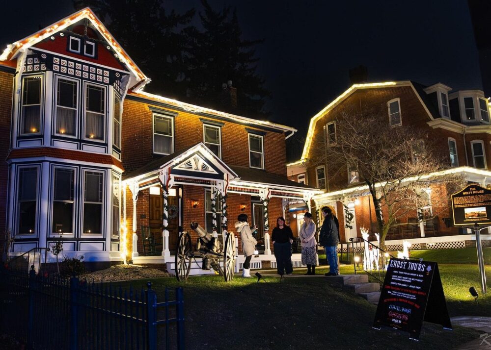 Brick house with party guests standing out front. 