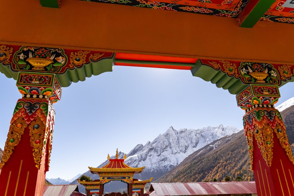 Red arches of a monastery with the snowy mountains beneath it