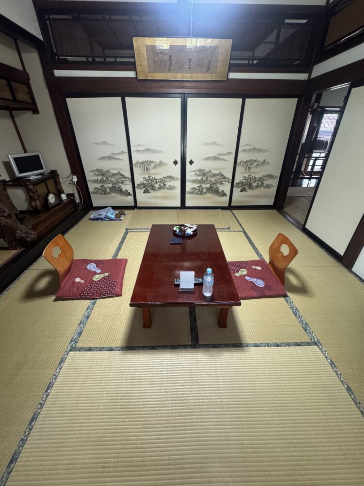 A tatami mat room with a small dining table set up  