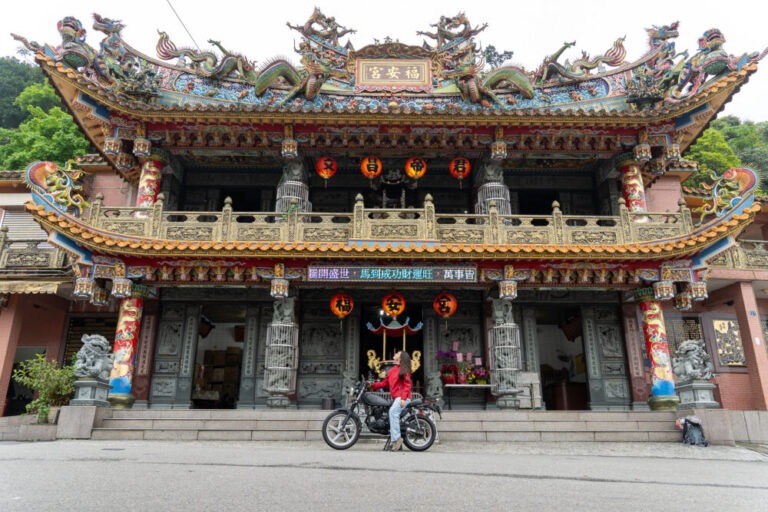 woman on motorcycle in front of a temple